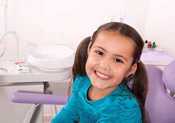 Young girl in an orthodontists office smiling